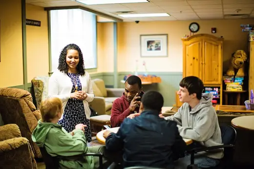 Welcoming common area with residents engaging at tables at Interfaith Partnership for the Homeless sober living home in Albany.